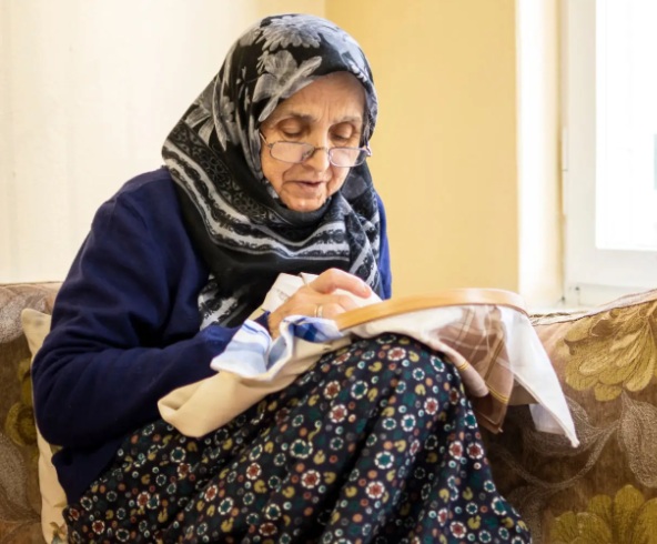 Older adult engaged in cross-stitch