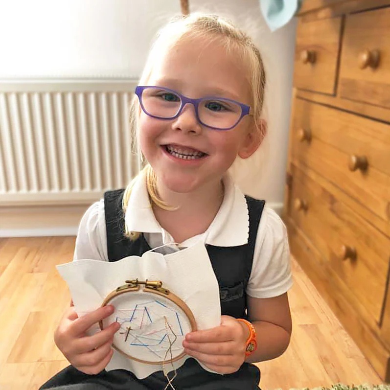 Young person engaged in cross-stitch